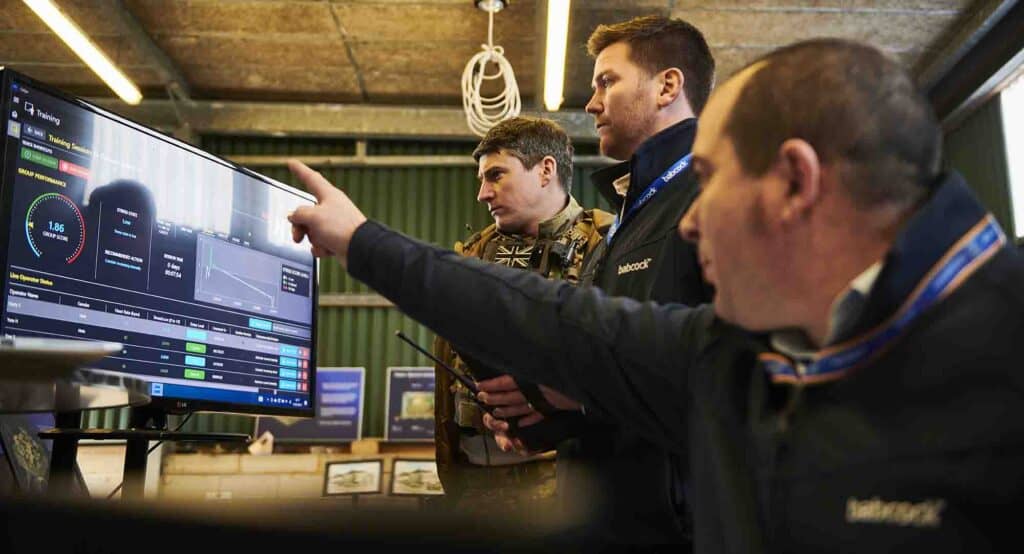 Image of Babcock staff engaged in immersive training British Army soldiers at computer monitor