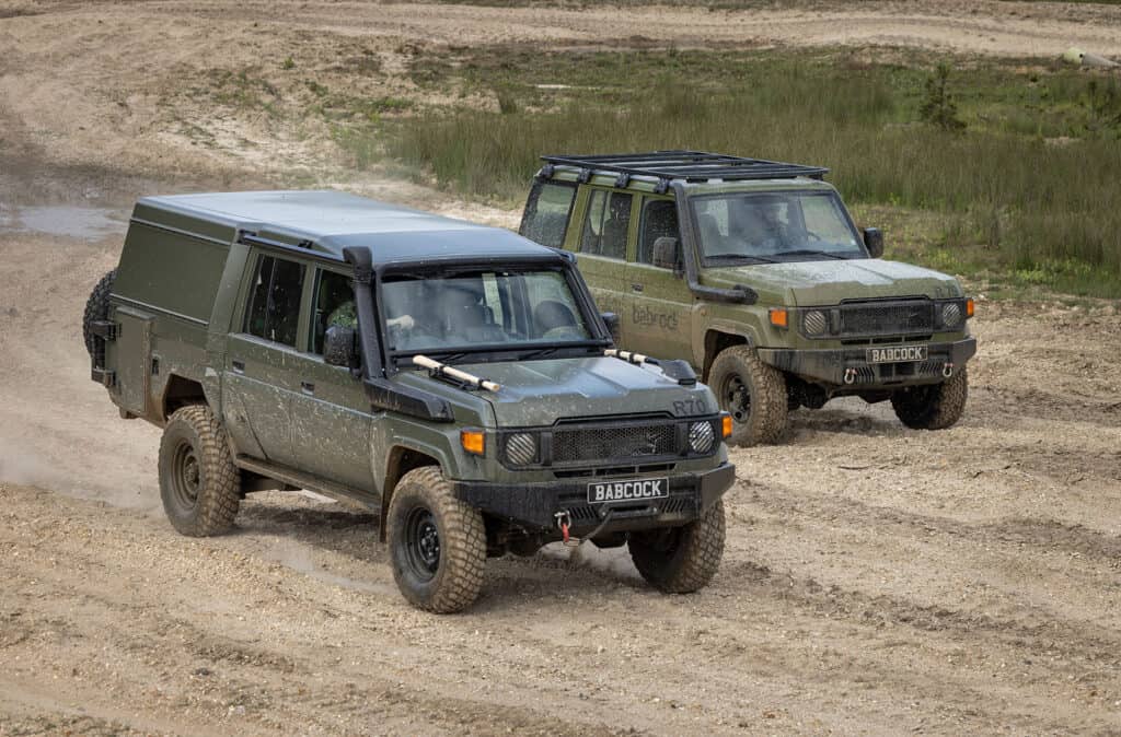 Two general logistics vehicles driving off road side by side