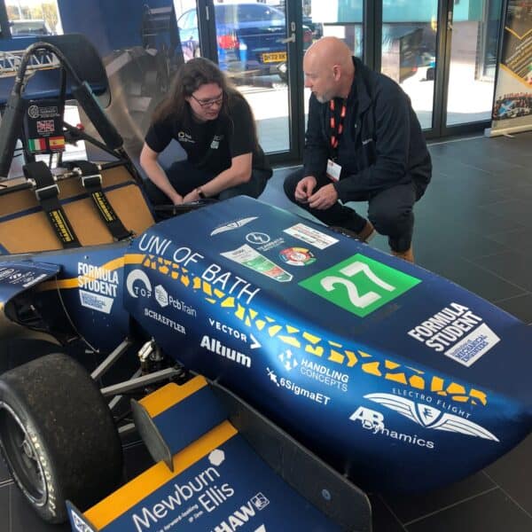 Two people looking at a Formula Student race car